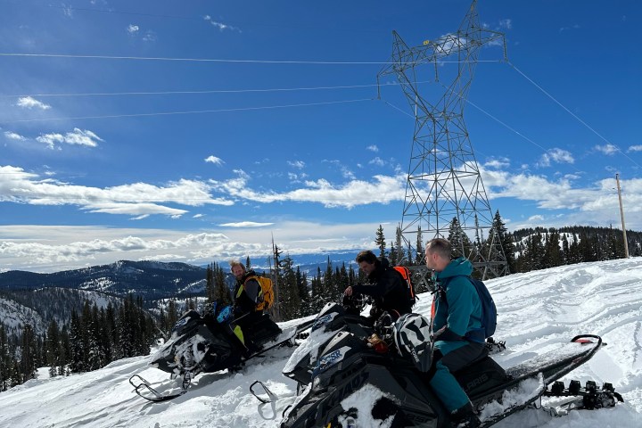 a group of people standing on top of a snow covered slope