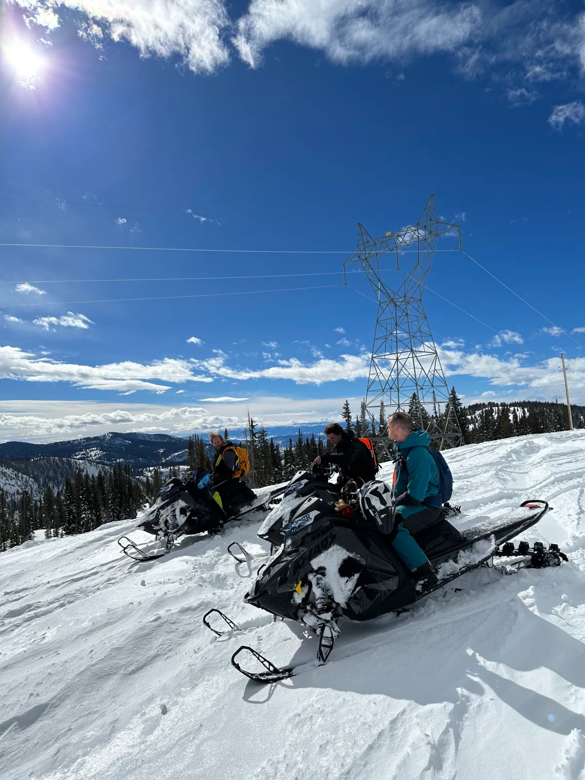 Three snowmobilers on a guided ride with big mountain views near Steamboat Springs