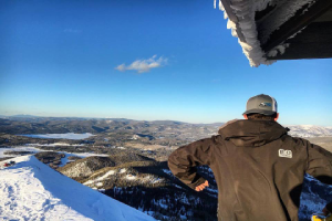 a man standing on a snow board high in the sky