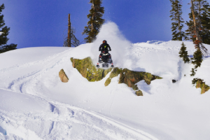 a man jumping in the air on a snow covered slope