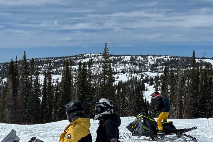 a group of people sitting in the snow