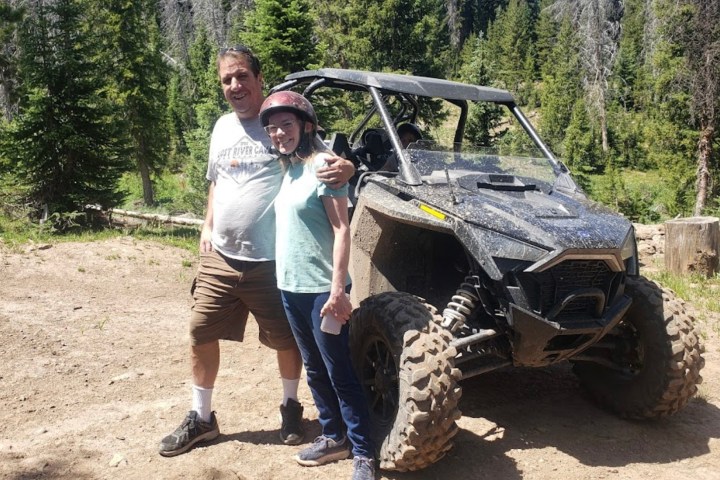 a couple riding a RZR