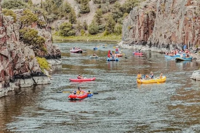 a group of people riding on the back of a boat in the water